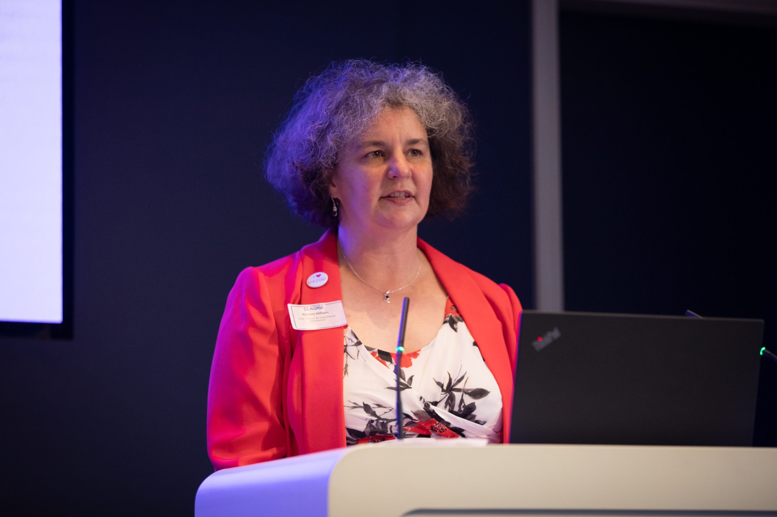 Woman at lectern addressing audience