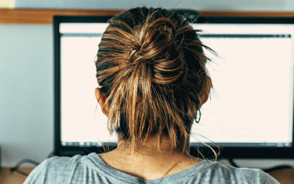 Back of head of woman looking into a computer screen