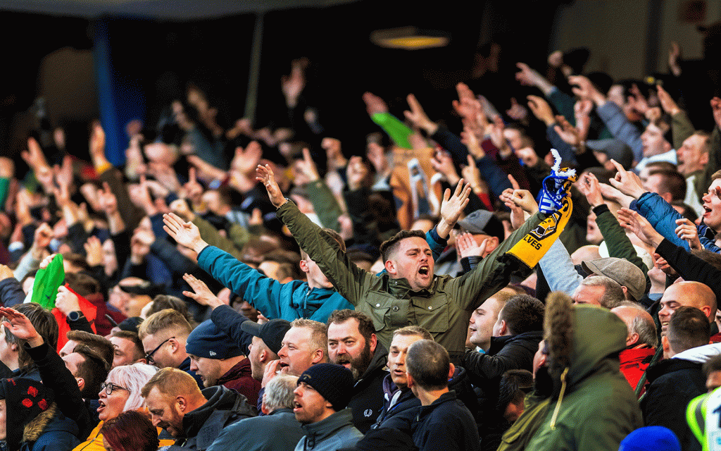 Football fans cheering their team in a stadium