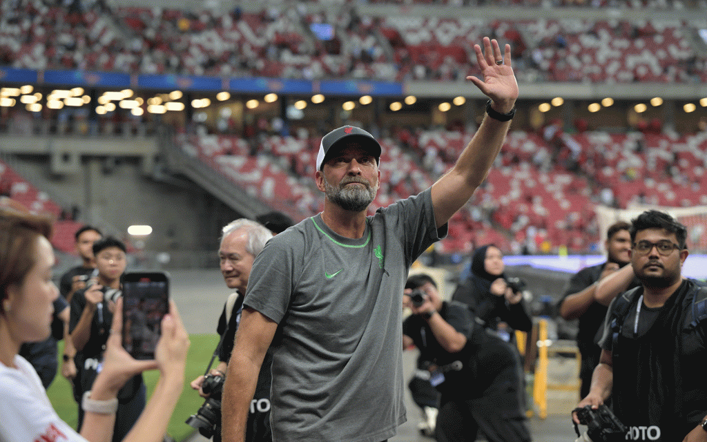 Liverpool football club manager Jurgen Klopp waves to fans from pitch